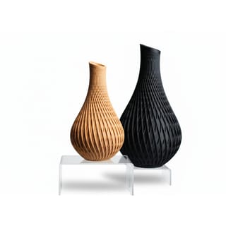 Designové vázy Vanta: dvě varianty s mřížkovým vzorem, hnědá a černá na podstavcích.