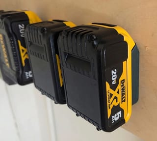 Držáky na baterie DeWalt 20V, několik baterií upevněných na dřevěné stěně v akci.