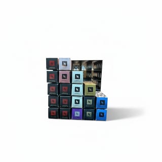 Nespresso kapsle v baleních různých barev úhledně uspořádané do stojanu.