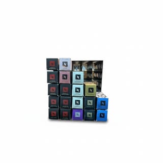 Nespresso krabičky různých druhů kapslí naskládané, s částí stojanu v pozadí.